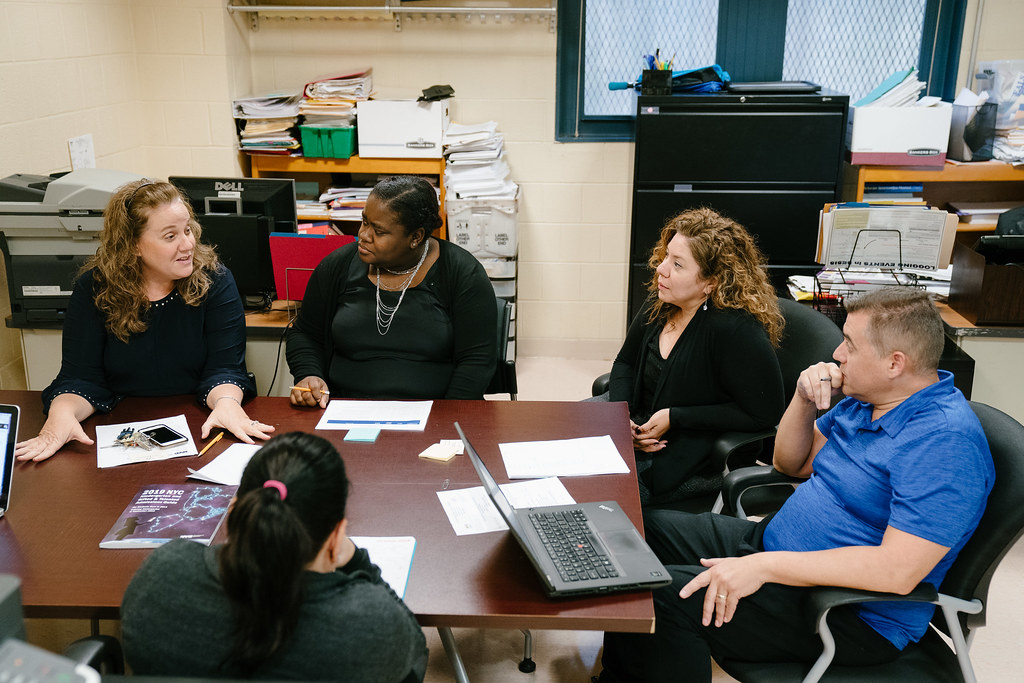 A group of teachers sitting around and talking during a meeting.